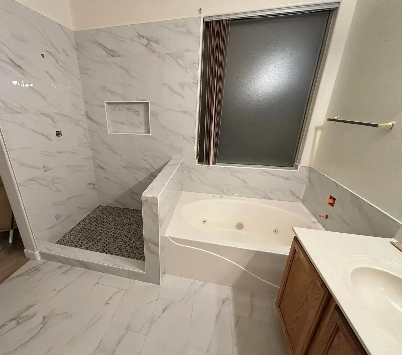 Arizona master bath remodel with white marble shower, recessed niche, jetted soaker tub, and frosted window
