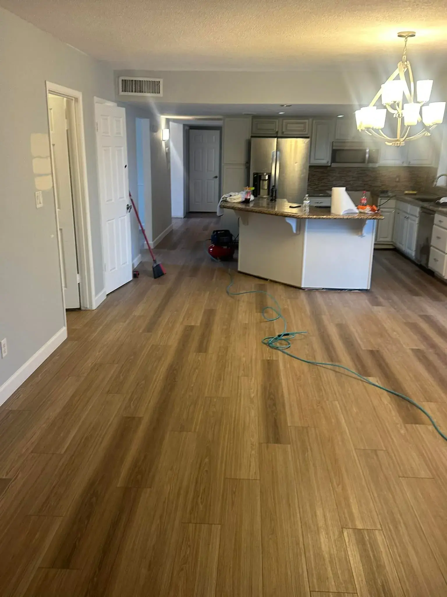Finished Arizona living room with rich brown luxury vinyl plank flooring and granite countertops installed by Zona Floors