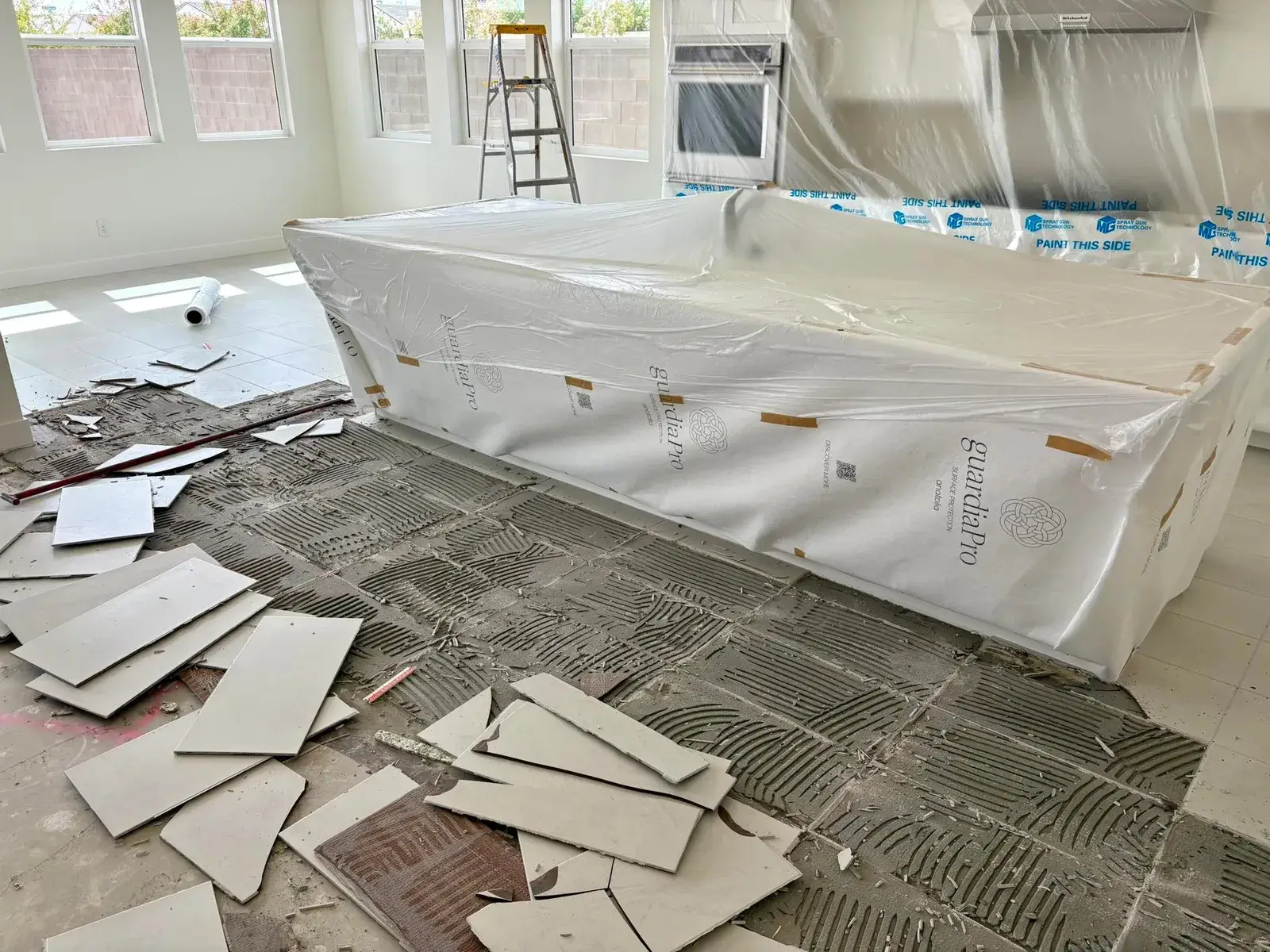 Two licensed Zona Floors installers in branded shirts laying luxury vinyl plank flooring on a customer-supplied job in Arizona