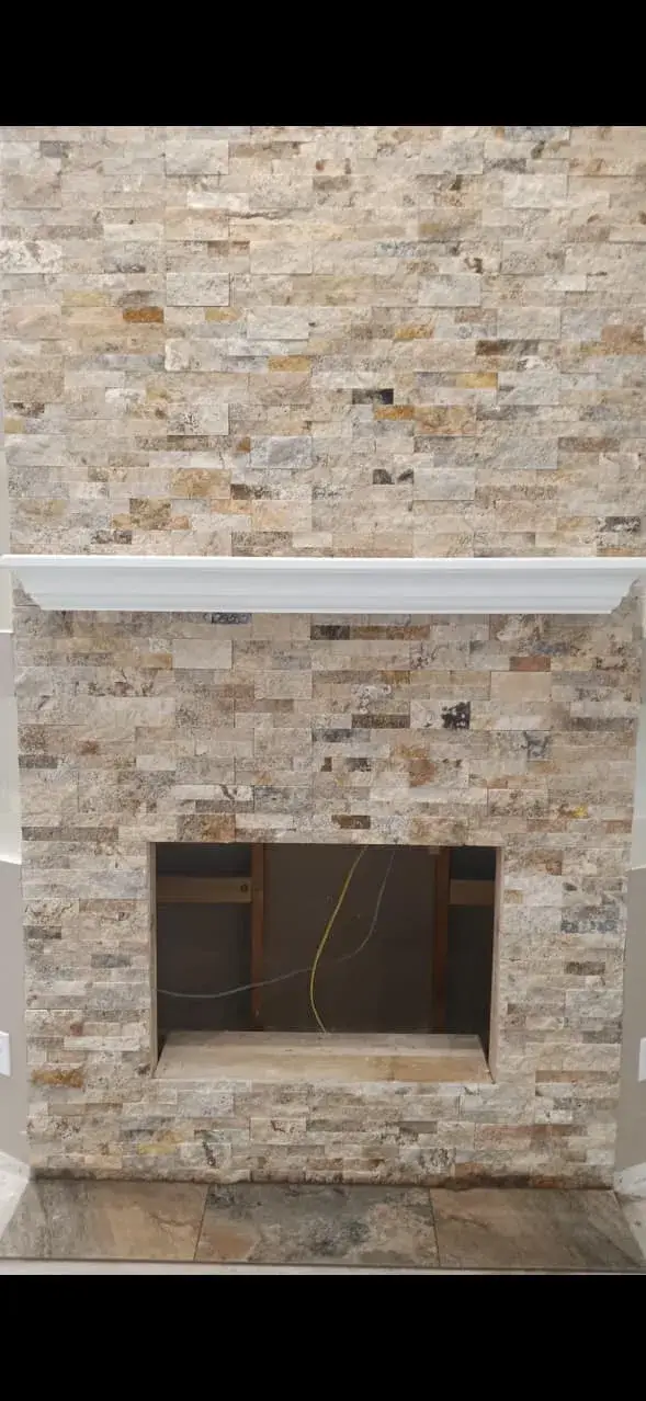 Stacked travertine stone fireplace surround with custom mantel installed by Zona Floors in an Arizona home